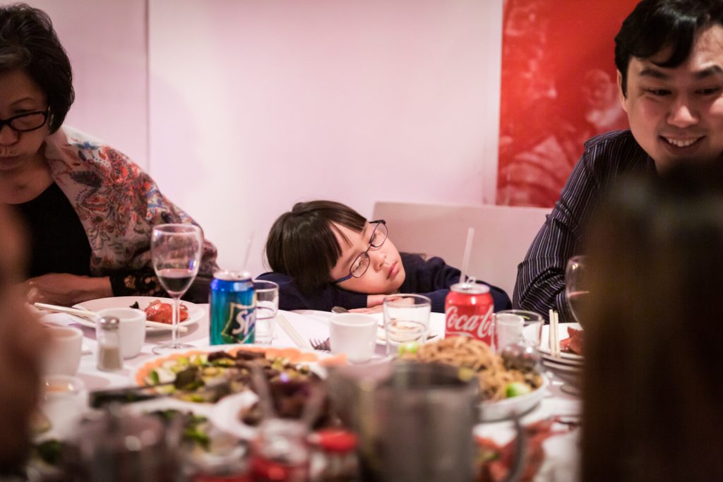 Little girl asleep at table at a Chinatown rehearsal dinner