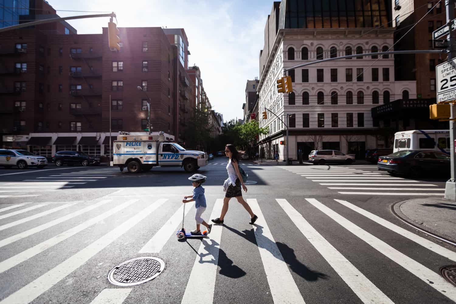 Mother and little boy on scooter walking in crosswalk during a day in the life photography session