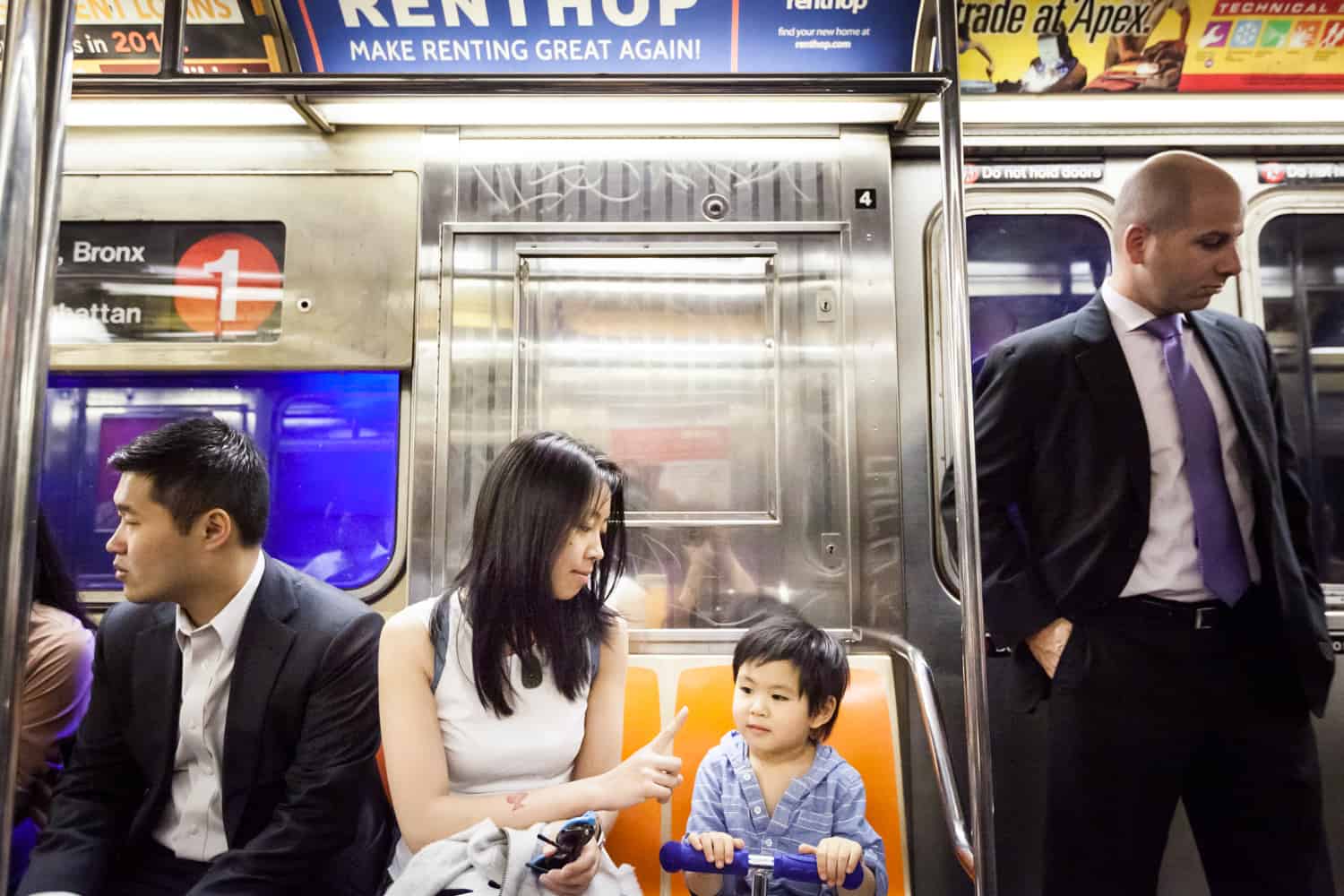 Mother and little boy sitting on subway train during a day in the life photography session