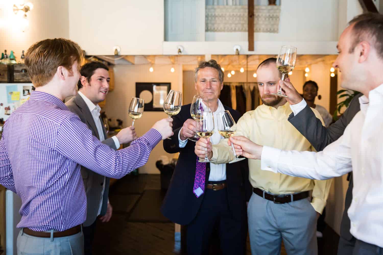 Groom and groomsmen toasting glasses before wedding