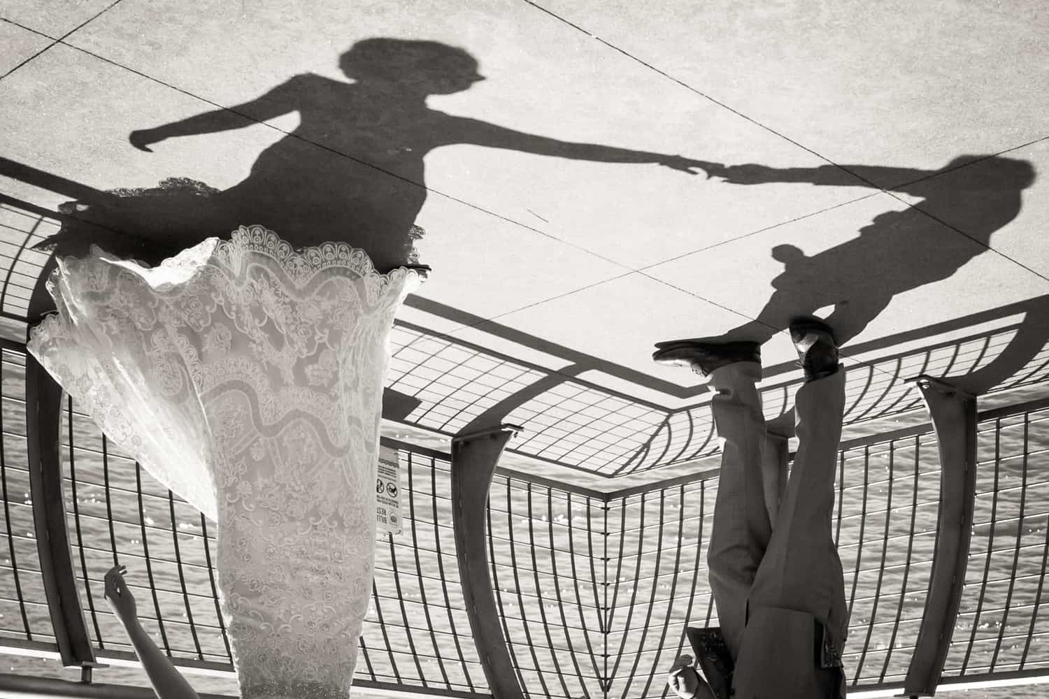 Black and white photo of shadow of bride and groom dancing