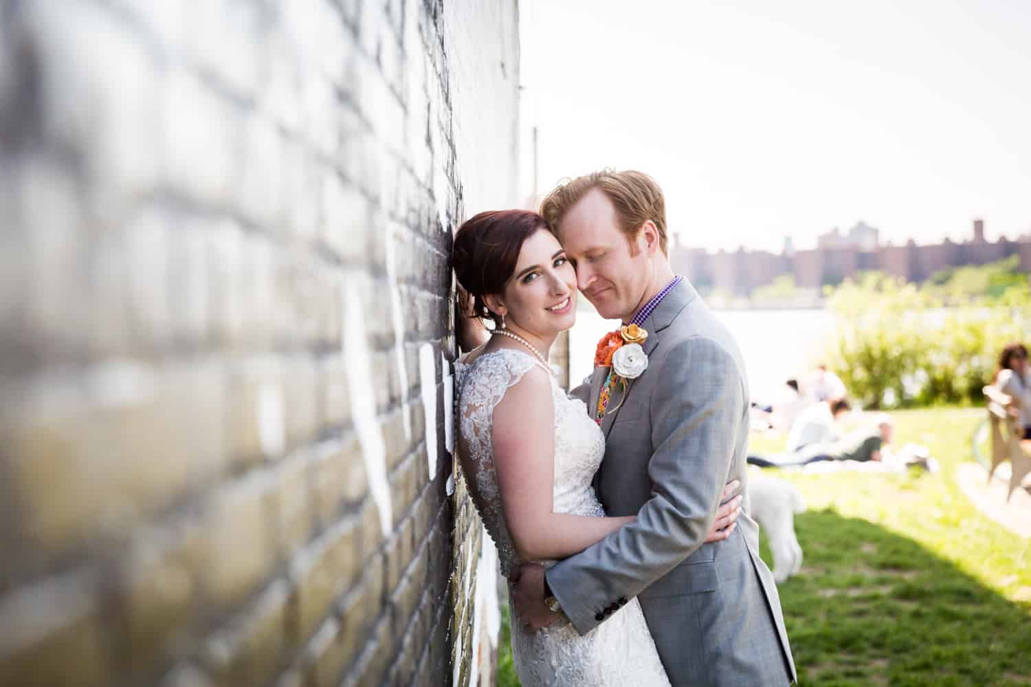 Bride and groom leaning against brick wall at a Greenpoint Loft wedding