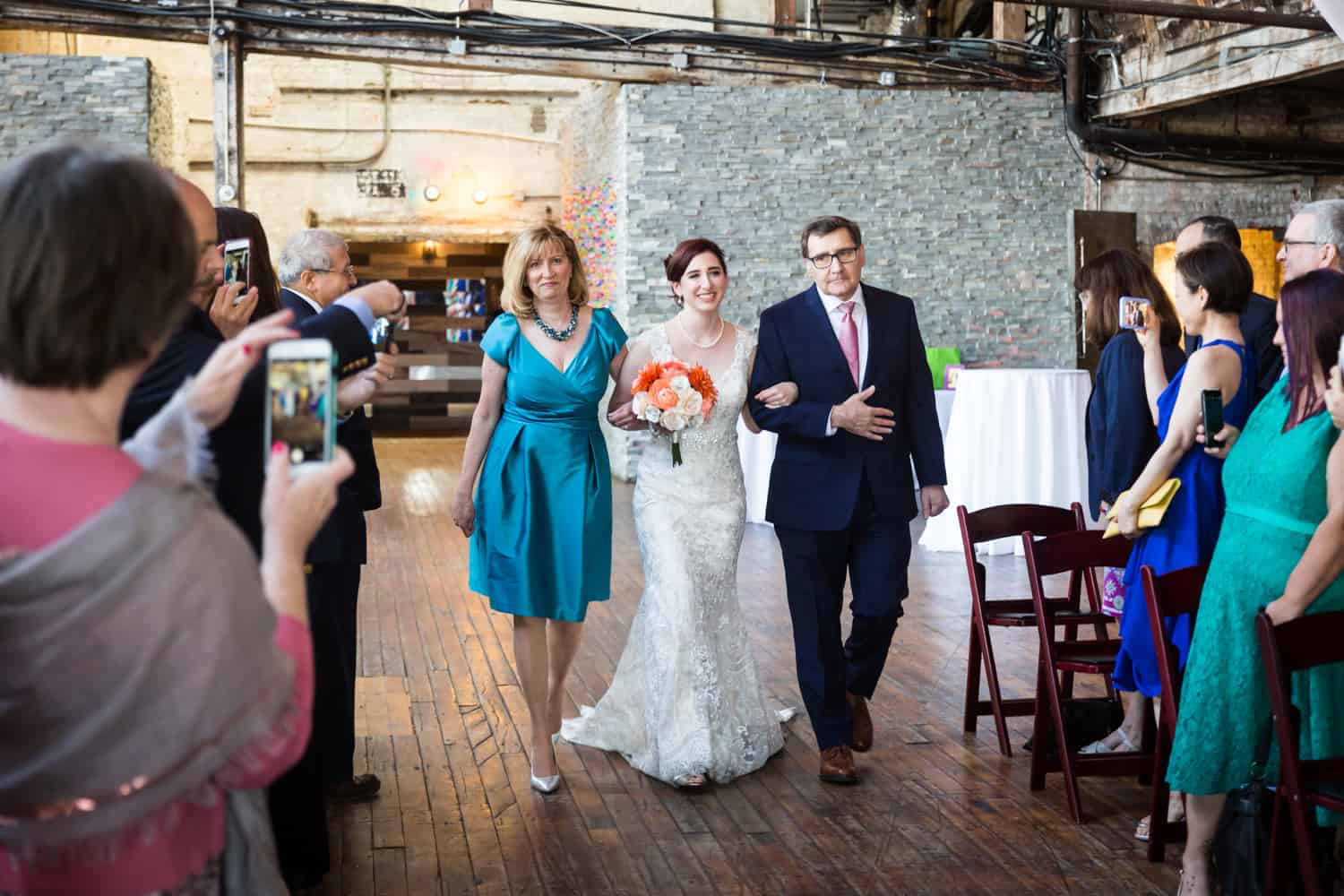 Bride walking up aisle with both parents at a Greenpoint Loft wedding