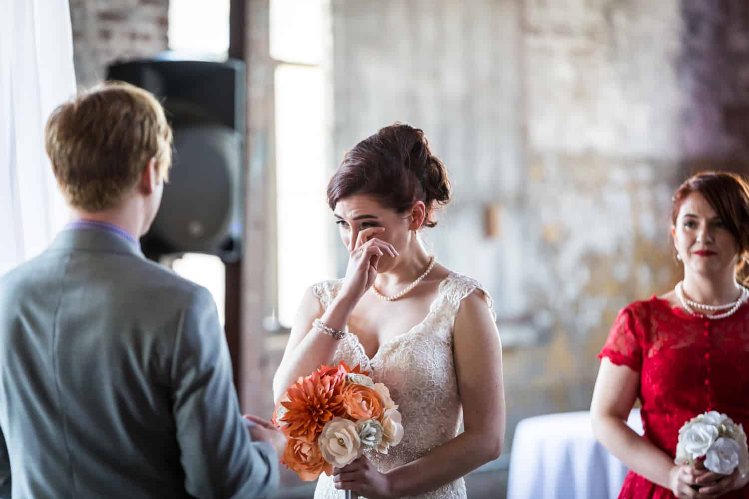 Bride wiping away tear during ceremony at a Greenpoint Loft wedding