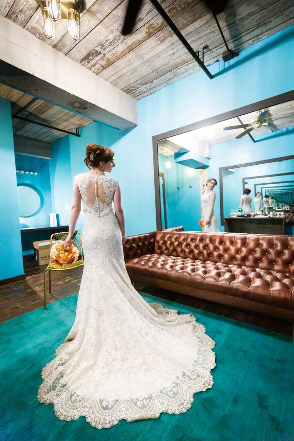 Bride with long train on dress reflected in mirror