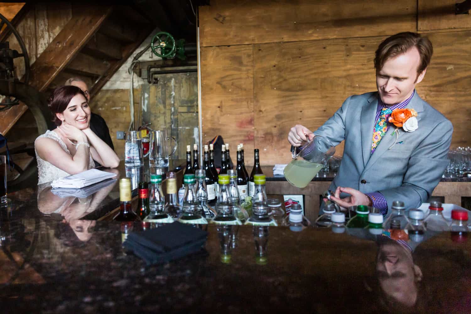 Groom preparing cocktail for bride at a Greenpoint Loft wedding