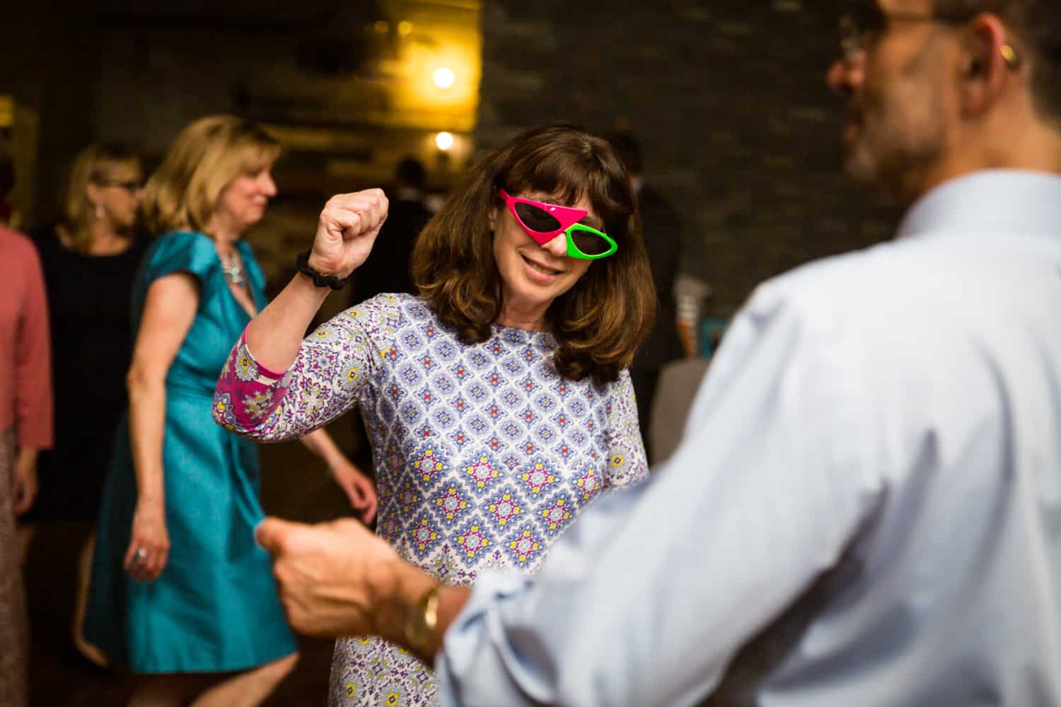 Guest dancing with 80s-style sunglasses at a Greenpoint Loft wedding