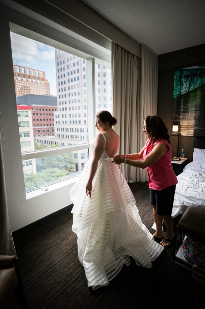 Bride getting into dress before a Brooklyn Historical Society wedding