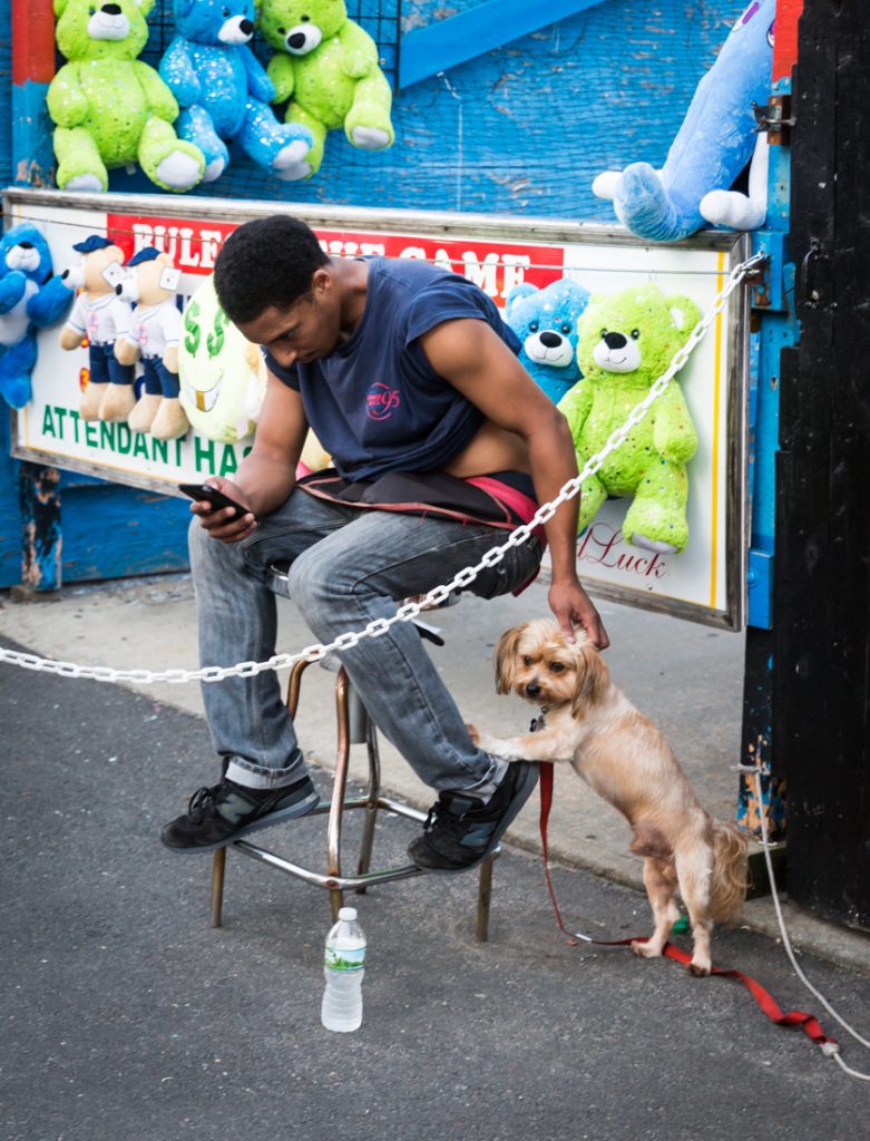 Coney Island carnival worker petting dog