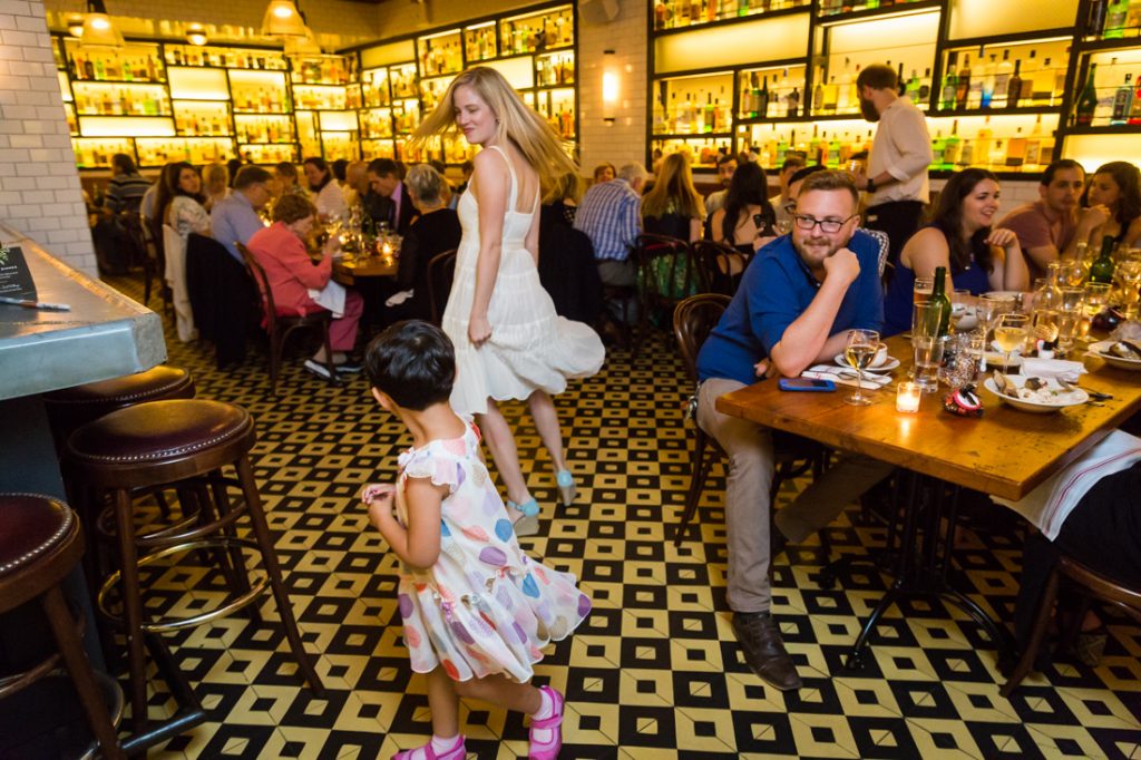 Little girl and bride at a rehearsal dinner for an article on details your wedding photographer needs to know