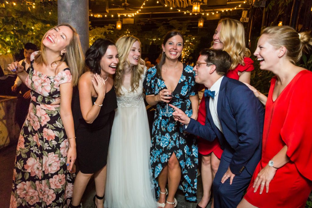 Bride laughing with five female guests and one male guest