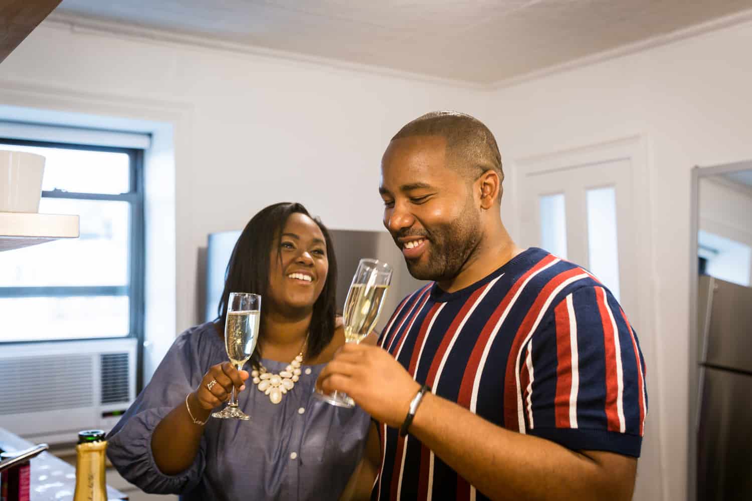 African American couple drinking from champagne flutes for an article on creative engagement photo shoot ideas