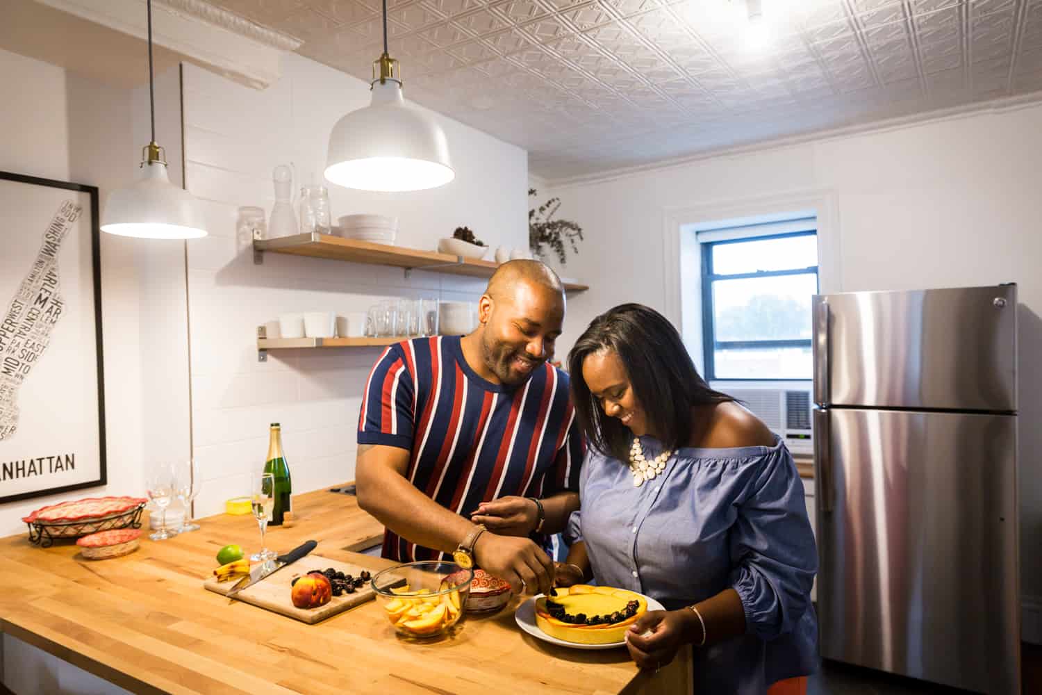 Couple cutting fruit tart for an article on creative engagement photo shoot ideas