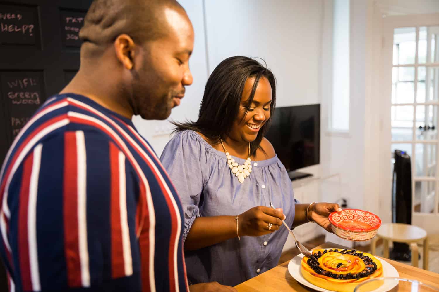 African American couple serving fruit tart for an article on creative engagement photo shoot ideas