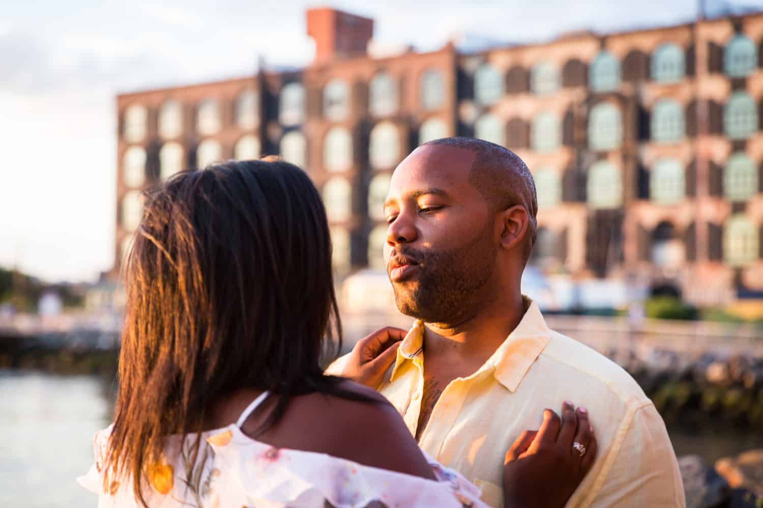 African American couple hugging along Red Hook waterfront during engagement shoot