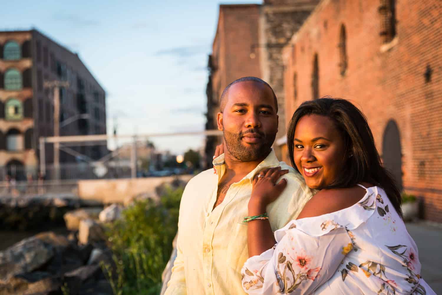 Couple in front of brick building in Red Hook for an article on creative engagement photo shoot ideas