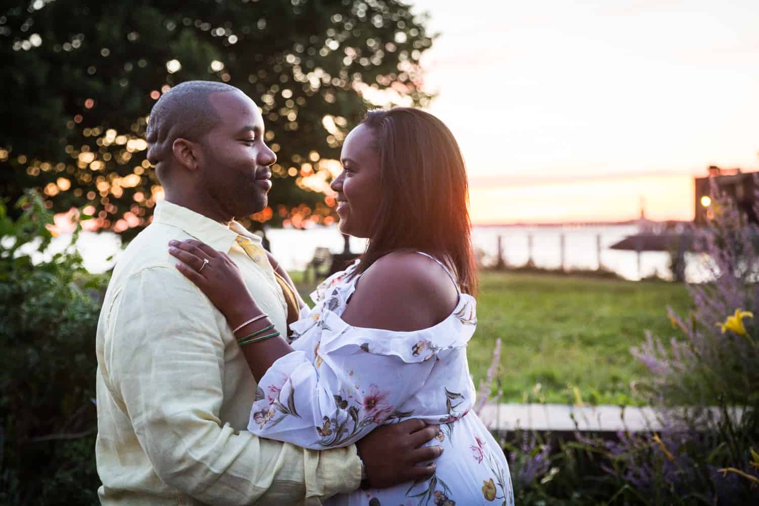 African American couple hugging along Red Hook waterfront during engagement shoot