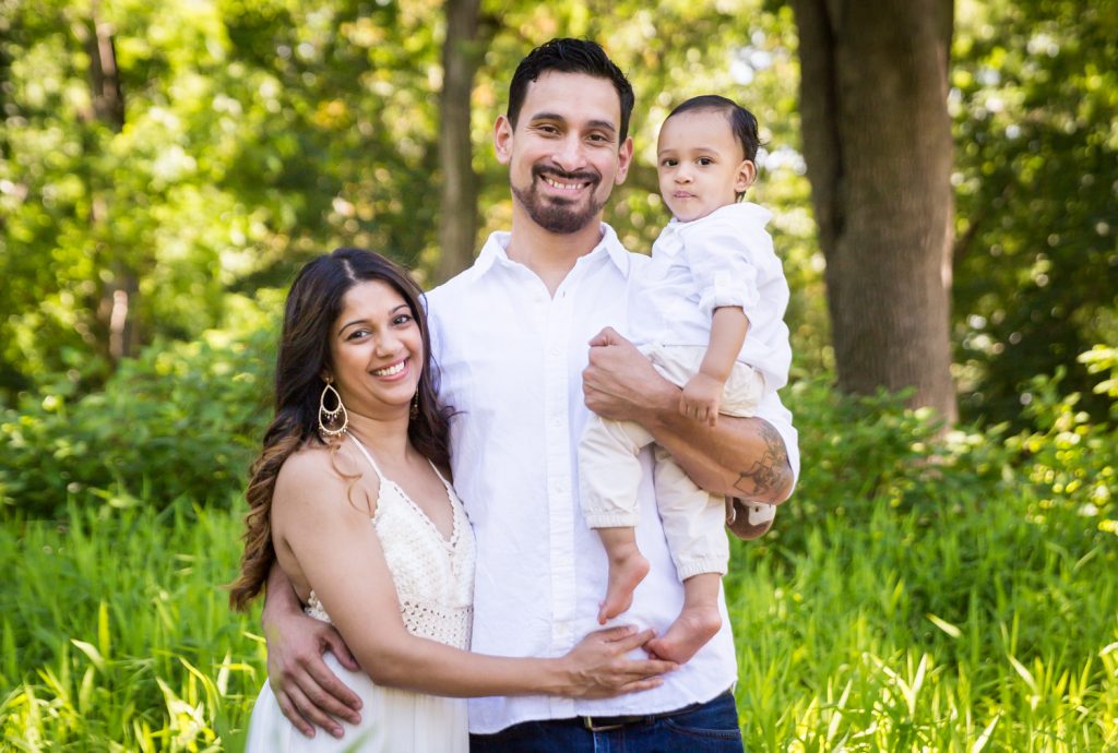 Forest Hills family portrait of mother and father holding baby