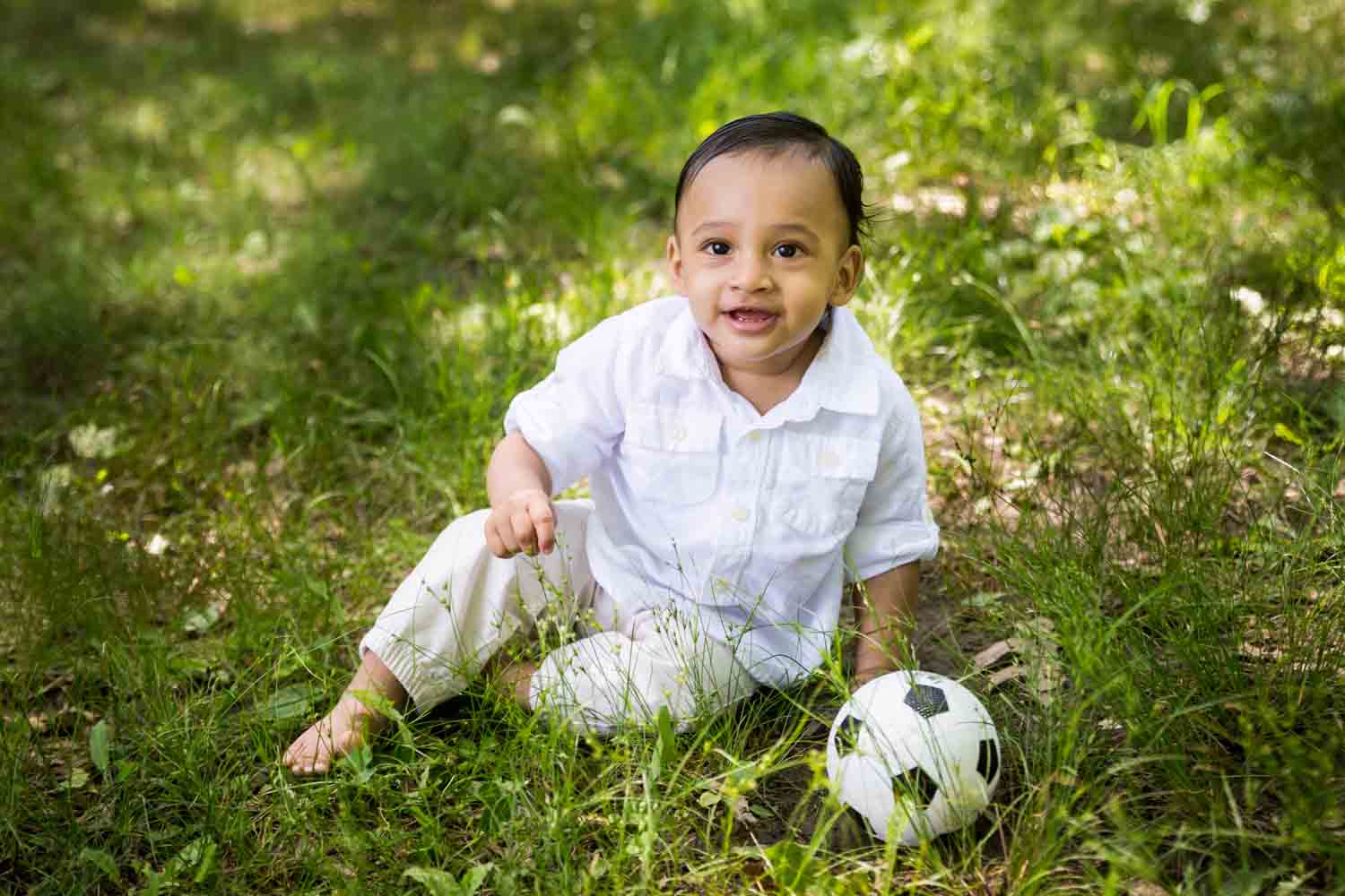Forest Hills family portrait of toddler sitting in grass with soccer ball