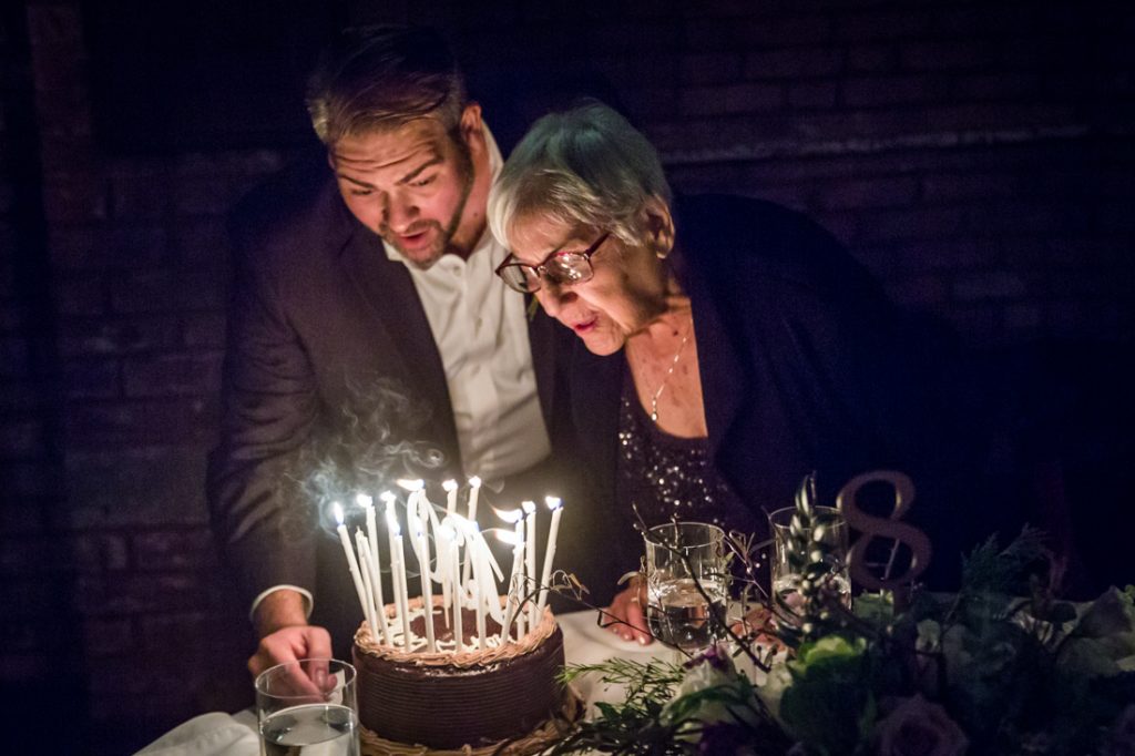 Grandmother and birthday cake at a 26 Bridge wedding
