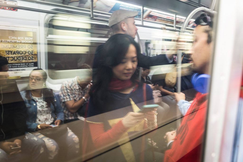 Couple commuting on the subway dressed as Spiderman and Supergirl for a Comic Con engagement shoot