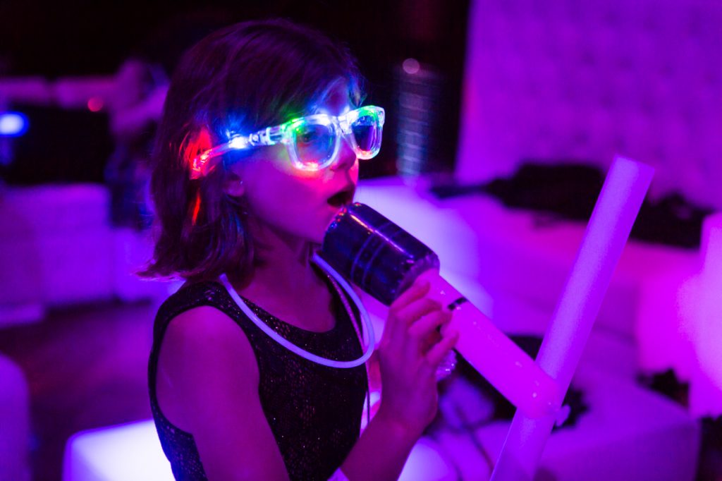 Kid with lit up glasses at a bat mitzvah for an article on ‘How to Find a Venue’