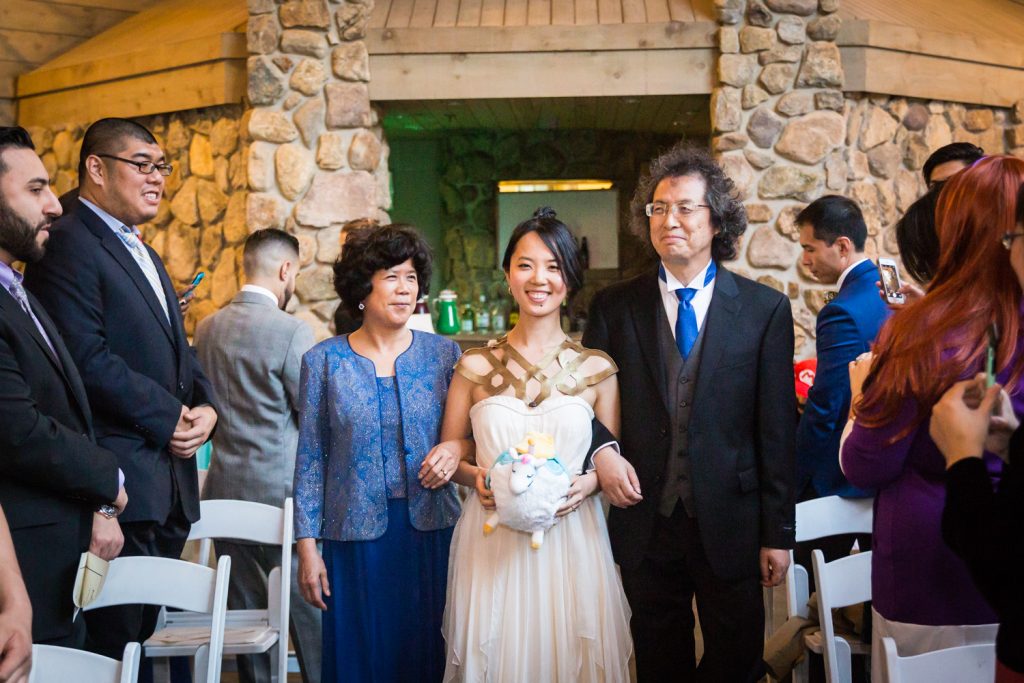 Bride walking down aisle escorted by both parents at a Bear Mountain Inn wedding