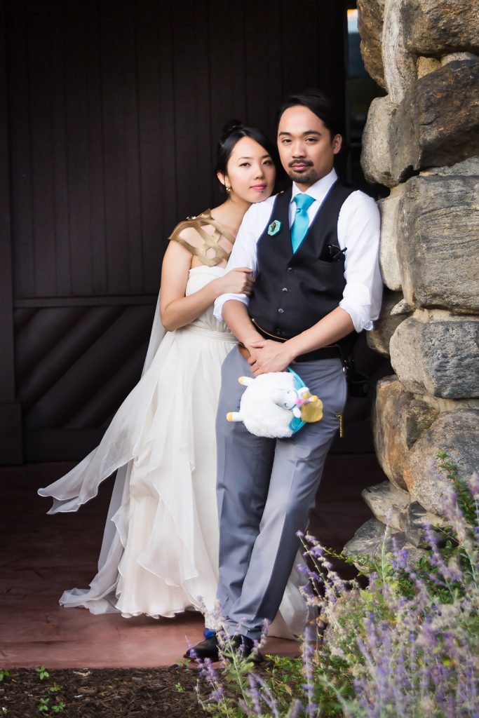 Bride and groom leaning against stone wall at a Bear Mountain Inn wedding