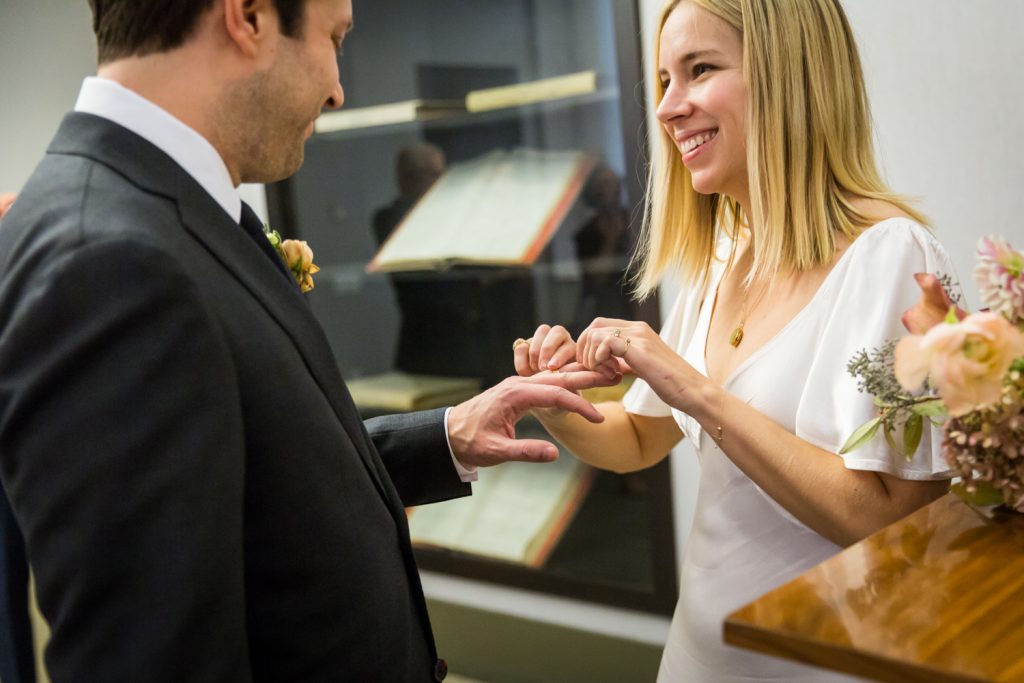 Bride and groom exchanging rings for an article on How to Get Married at City Hall in Any NYC Borough