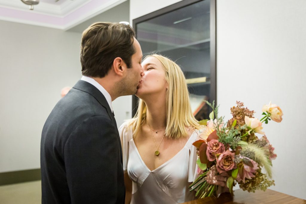 Bride and groom kissing for an article on How to Get Married at City Hall in Any NYC Borough