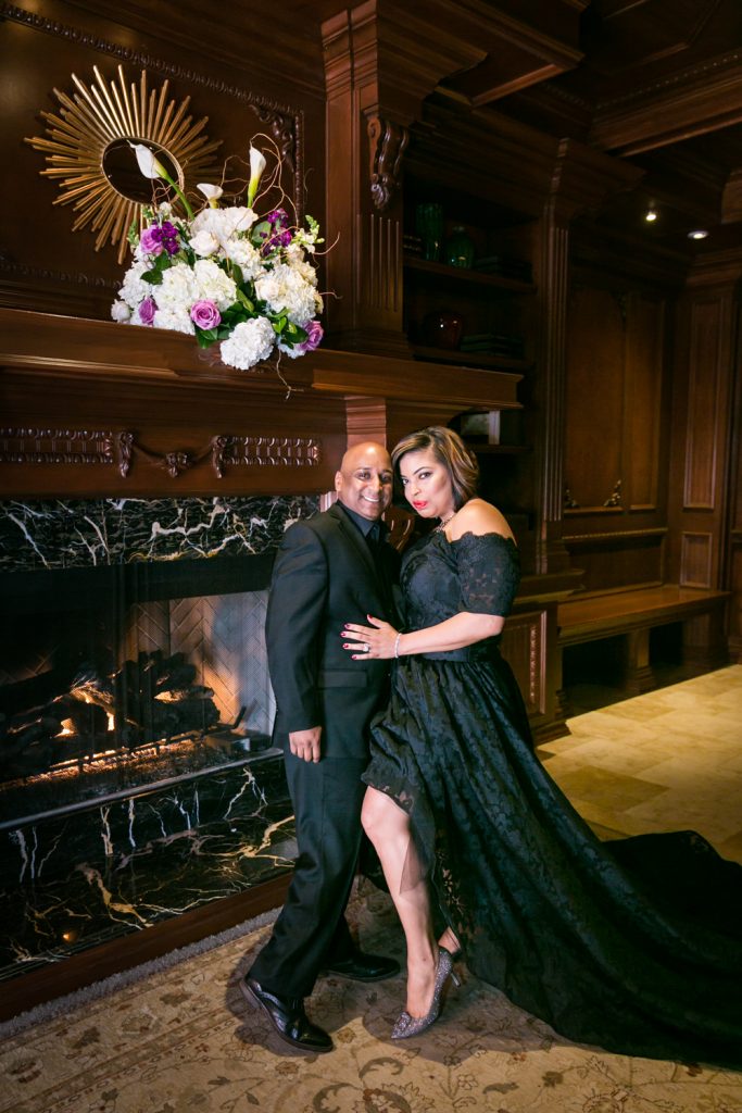 Bride and groom wearing black clothes in front of fireplace for an article on how to plan a Halloween wedding
