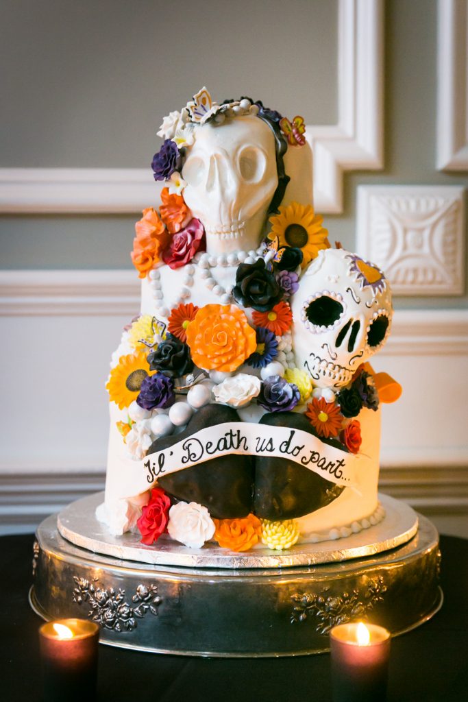 Halloween-themed wedding cake with sugar skulls