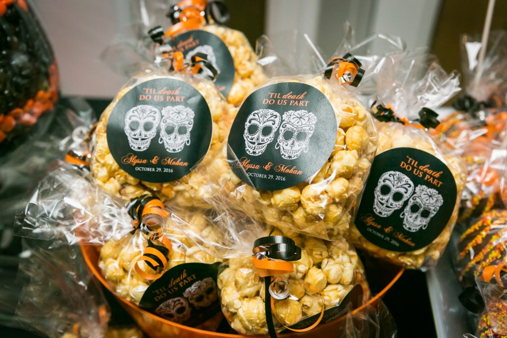 Bags of popcorn with personalized tags for an article on how to plan a Halloween wedding
