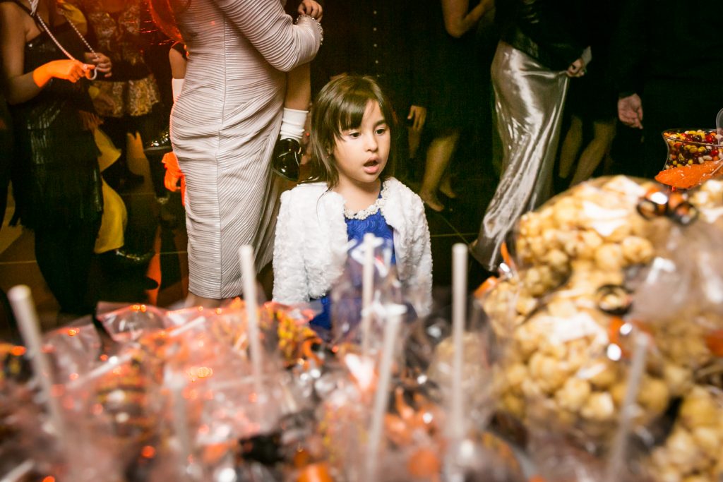 Little girl looking agape at candy buffet for an article on how to plan a Halloween wedding