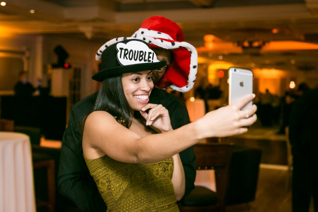 Guest wearing hat and taking selfie for an article on how to plan a Halloween wedding