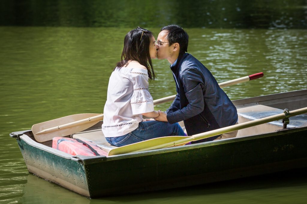 Man and woman kissing in boat after Central Park Lake proposal
