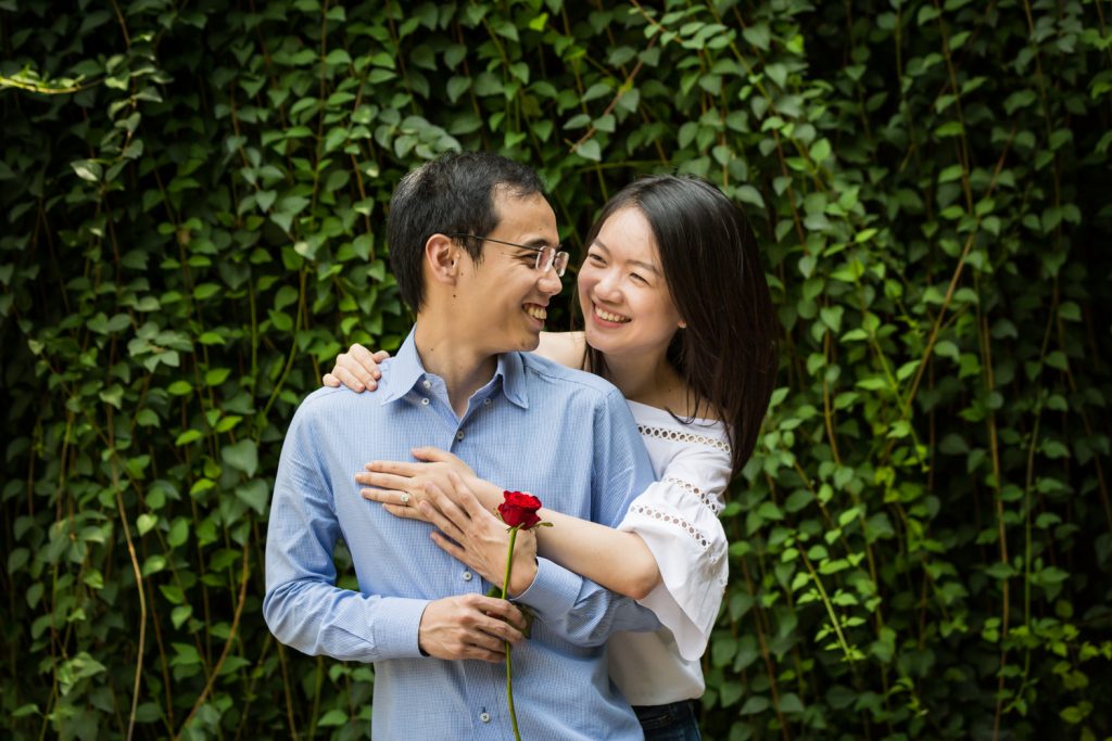 Engagement portrait of couple in front of ivy-covered Trefoil Arch after Central Park Lake proposal