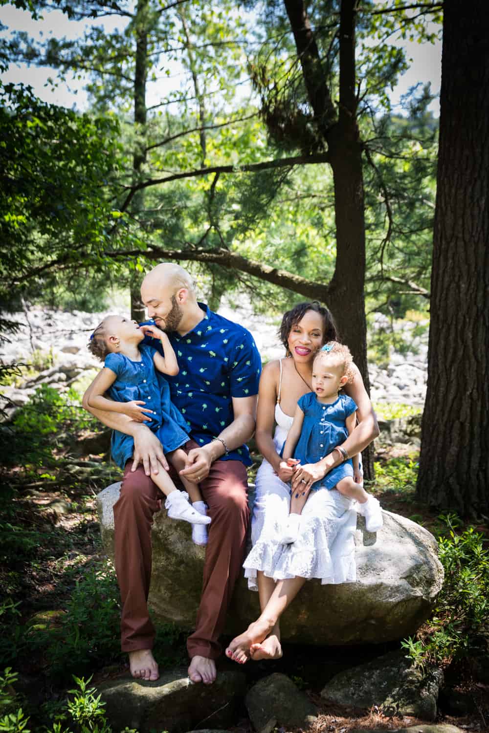 Parents attending to two children in the woods during a family reunion portrait