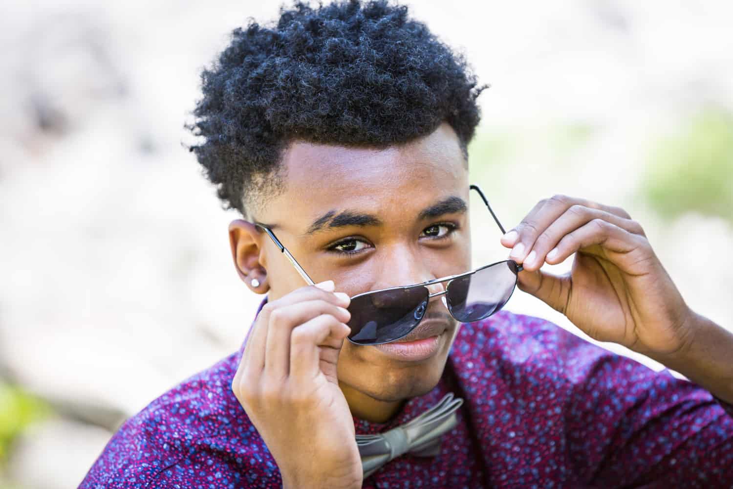 African American young man pulling down sunglasses