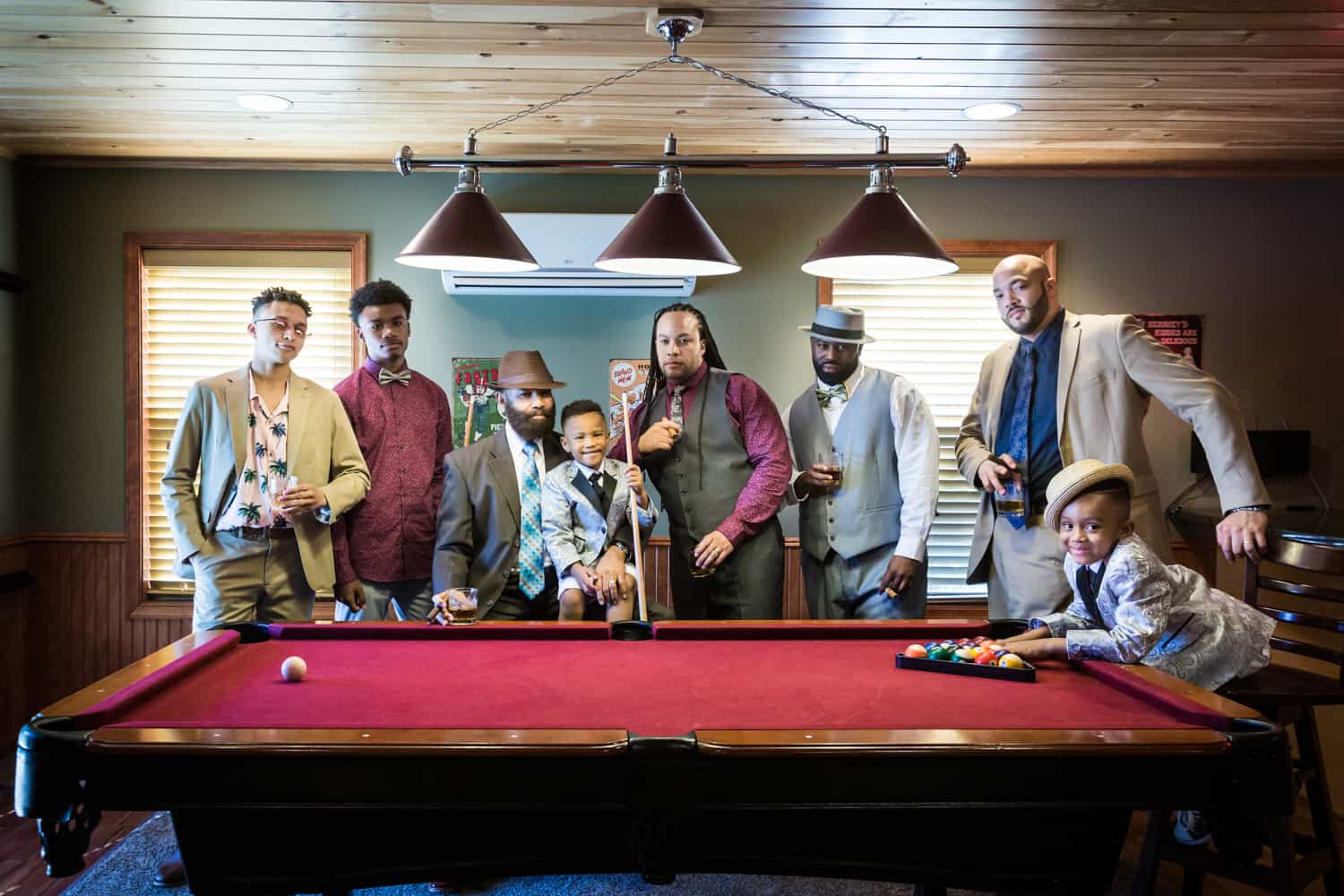 Male family members behind a pool table during a family reunion portrait