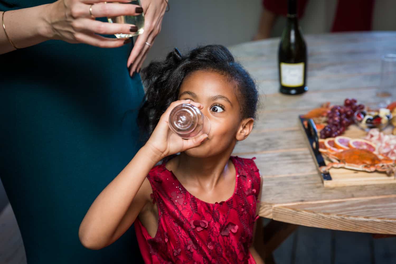 Little girl drinking from glass during a family reunion portrait