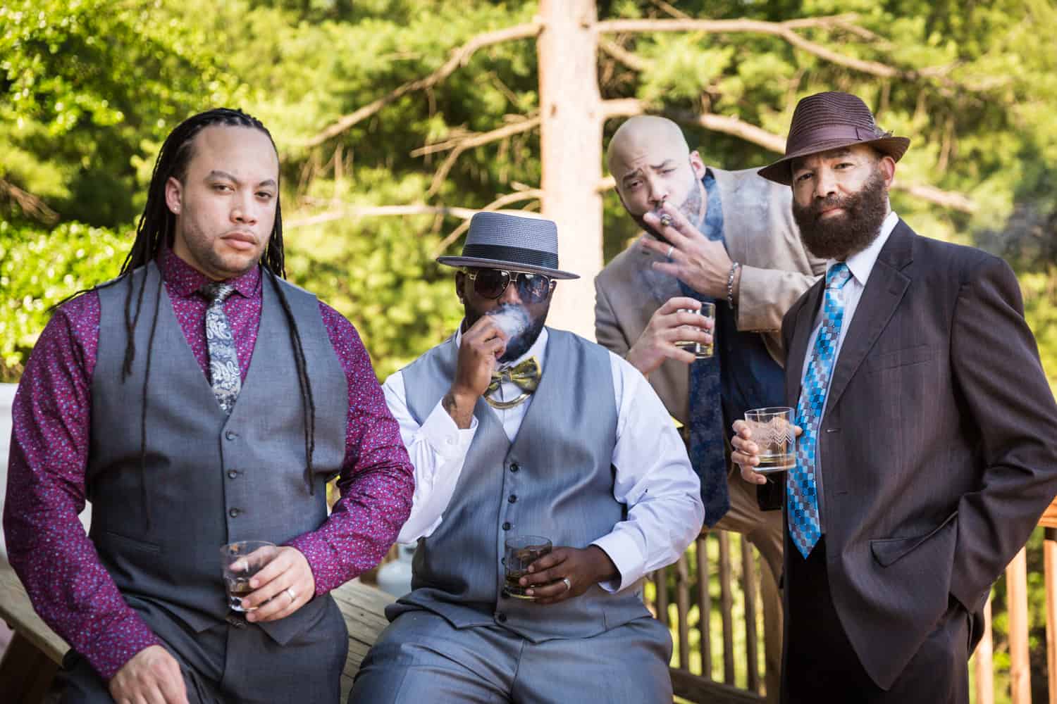 Male family members smoking together on porch during a family reunion portrait