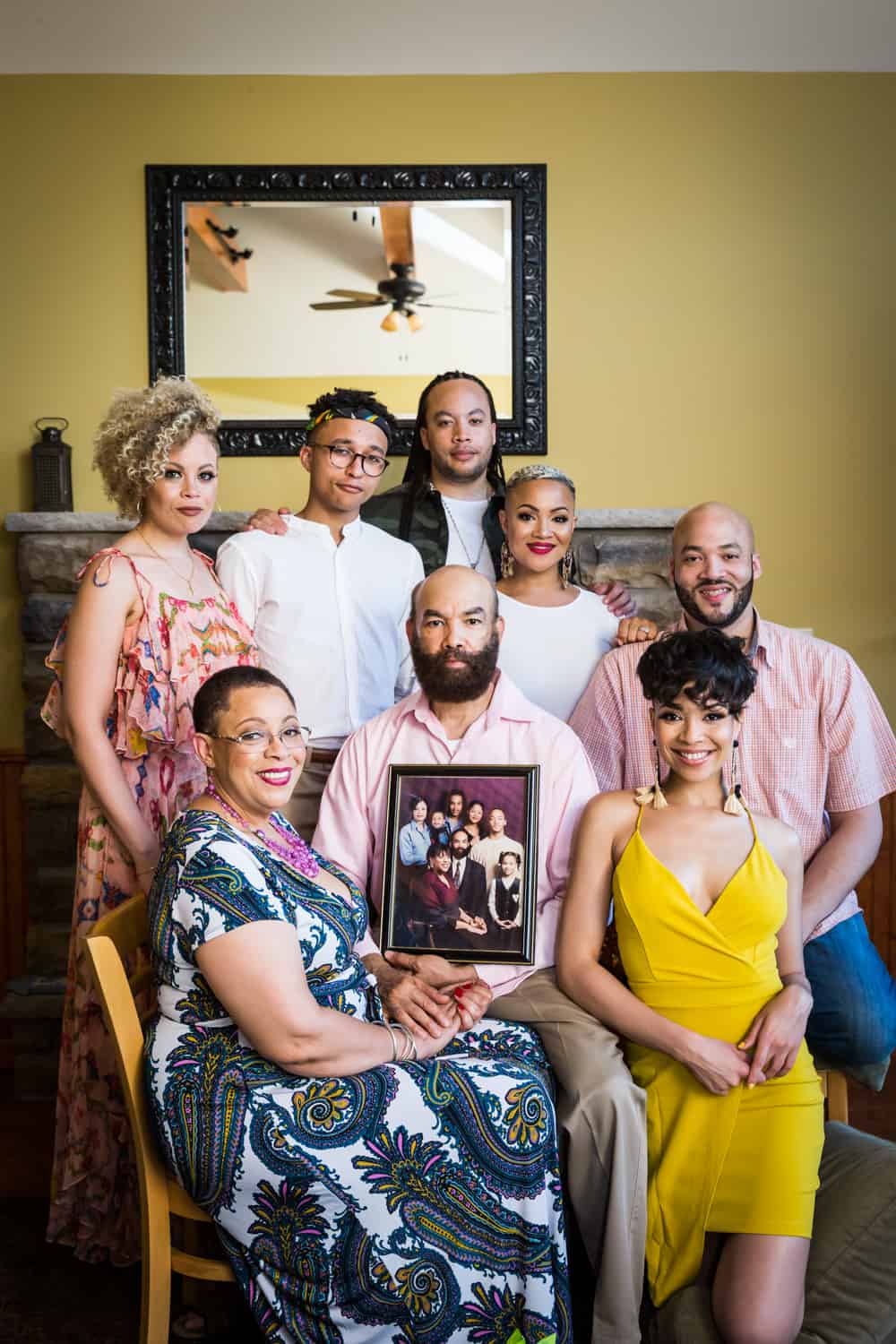 Family gathered around framed old photo of family during a family reunion portrait