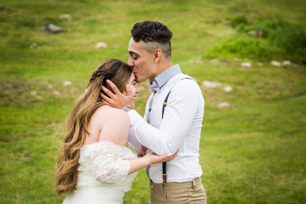 Groom kissing top of bride's head