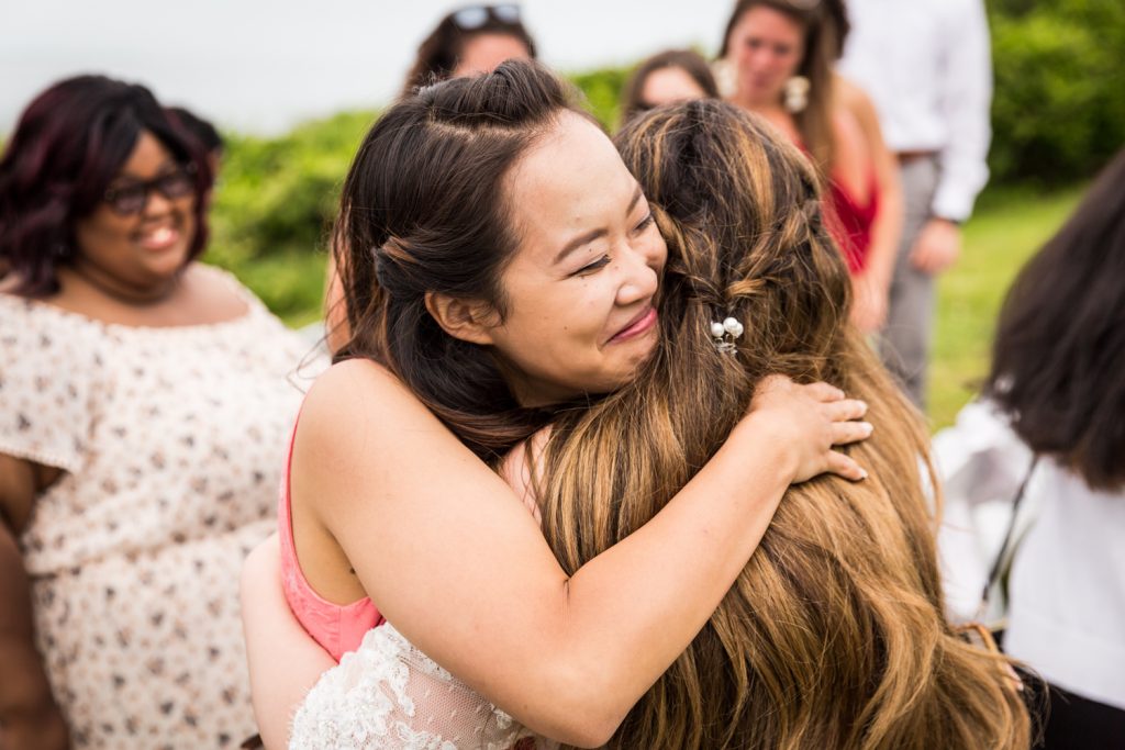 Guest hugging bride for an article on Montauk Lighthouse wedding tips