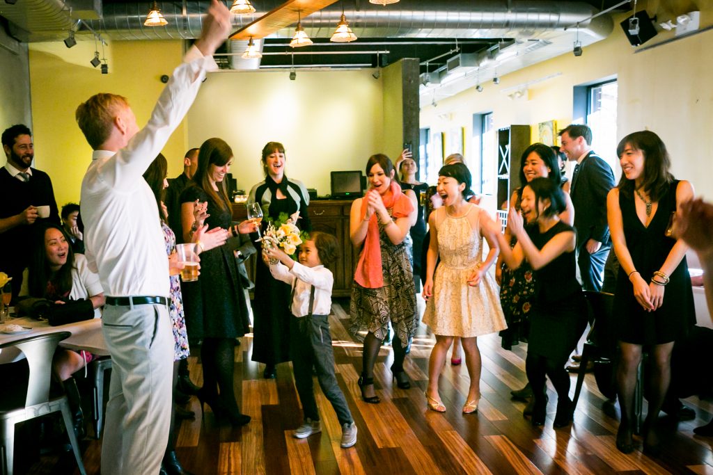 Little boy catching bouquet for an article on bouquet and garter toss alternatives