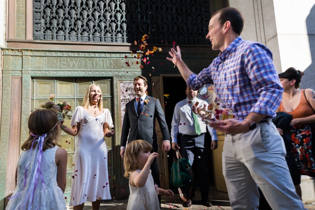 Couple with rose petals thrown for an article on City Hall wedding portrait locations