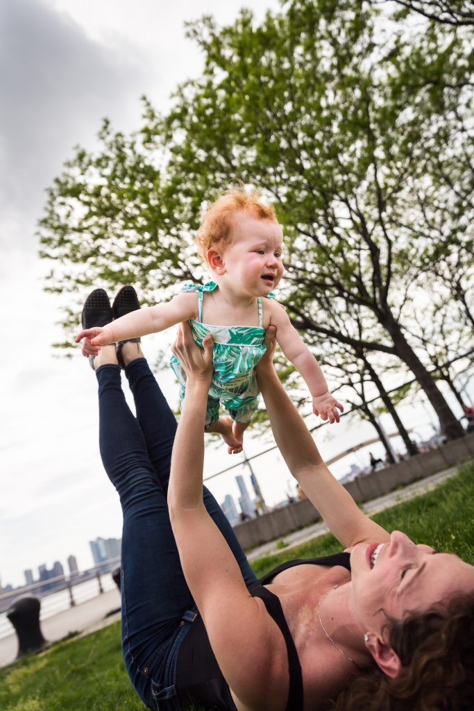 Smiling baby in the air in a Hudson River Park Family Portrait