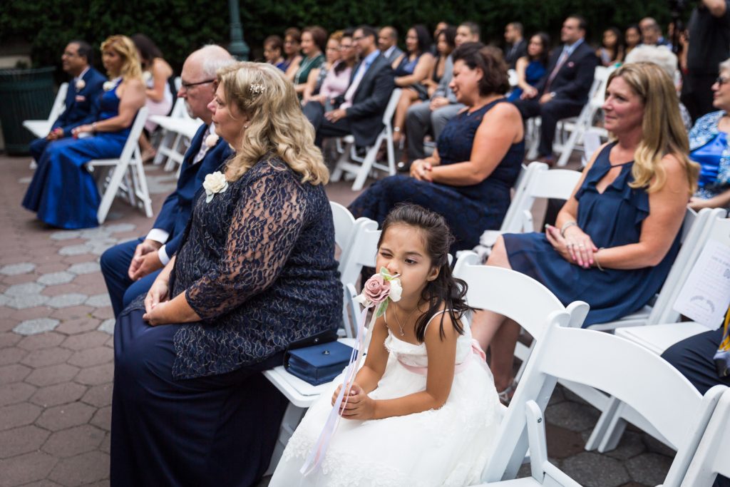 Flower girl smelling bouquet at a Bronx Zoo wedding