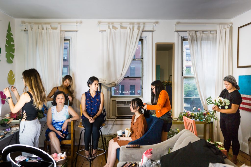 Bride, bridesmaids, and family getting ready in apartment for an article on the pros and cons of a restaurant wedding